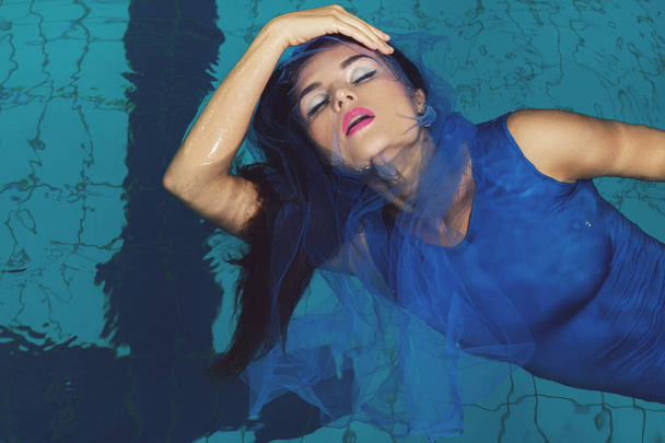 Sexy model with a beautiful make-up in the swimming pool - 写真・画像