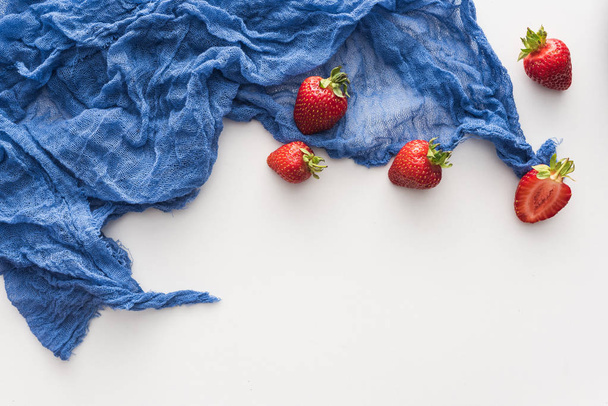 vista superior de fresas dulces y enteras sobre tela azul
  - Foto, imagen