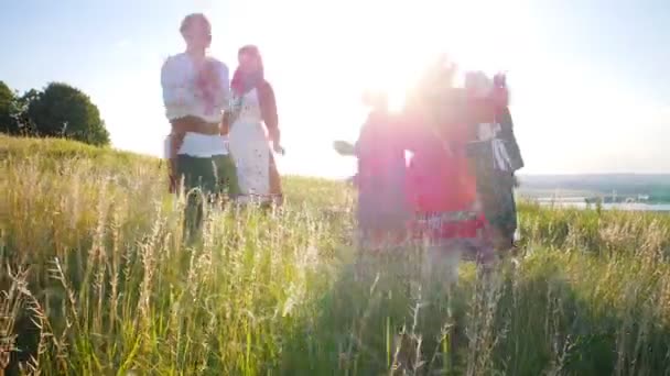 Lidé v tradičních ruských šatech, kteří chodí v kruhu a mají zábavné světlé světlo - Záběry, video