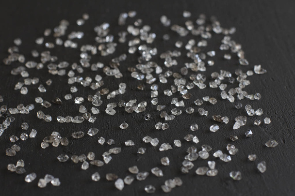 Scattered diamonds on a black background. Raw diamonds and minin - Foto, afbeelding