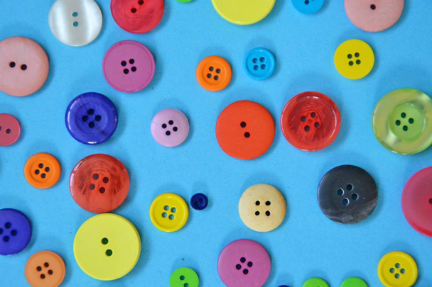 Um grande conjunto de botões em cores e desenhos diferentes na frente de um fundo colorido
  - Foto, Imagem