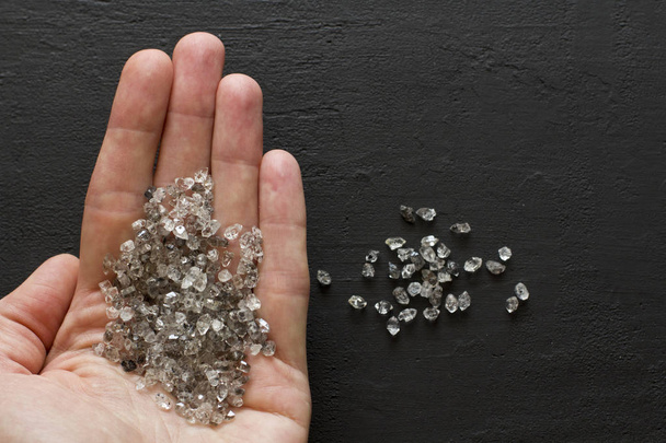 Surowe naturalne diamenty, grafitowy kwarc są w dłoni. Rozproszenie - Zdjęcie, obraz