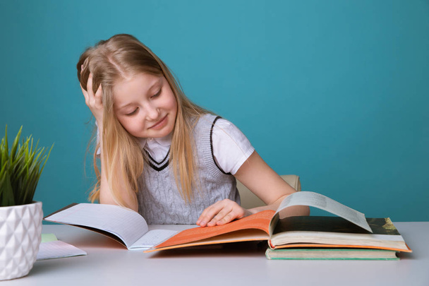 教育と学校のコンセプト-学校で多くの本を持つ笑顔の小さな学生の女の子 - 写真・画像