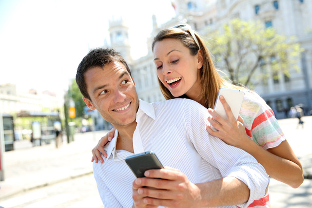 Girl reading message on boyfriend's smartphone - Fotó, kép
