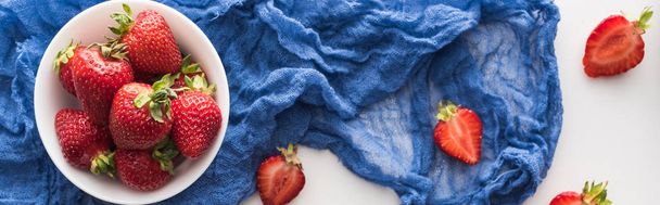 plano panorámico de fresas frescas y maduras en un tazón con tela azul
  - Foto, imagen