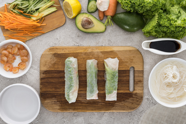 top view of spring rolls on cutting board among ingredients  - Photo, Image