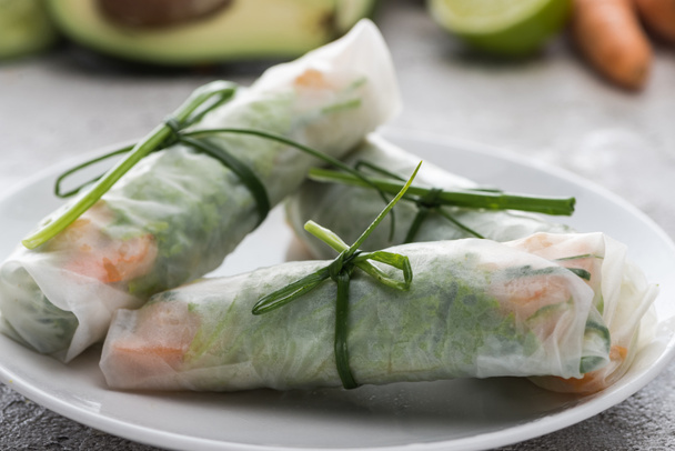 tasty and served spring rolls with onions on white plate  - Photo, Image