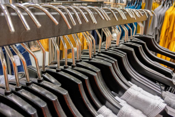 Clothes hang on a shelf in a designer clothes store. - Photo, Image