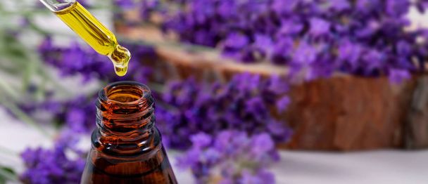 lavender essential oil dripping from dropper over the bottle. co - Photo, Image