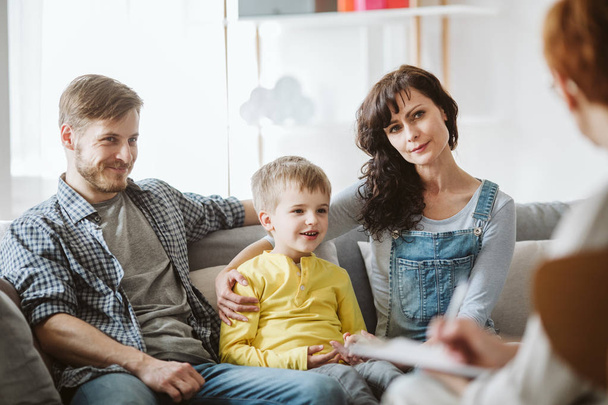 Caring parents and misbehaving boy during therapy session with counselor - Valokuva, kuva