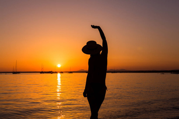 Sonnenuntergang, sexy Frauensilhouette. Unbekümmerte Frau genießt den Sonnenuntergang am Strand. glücklicher Lebensstil. Mallorca. es prenc beach. - Foto, Bild