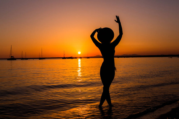 Sonnenuntergang, sexy Frauensilhouette. Unbekümmerte Frau genießt den Sonnenuntergang am Strand. glücklicher Lebensstil. Mallorca. es prenc beach. - Foto, Bild