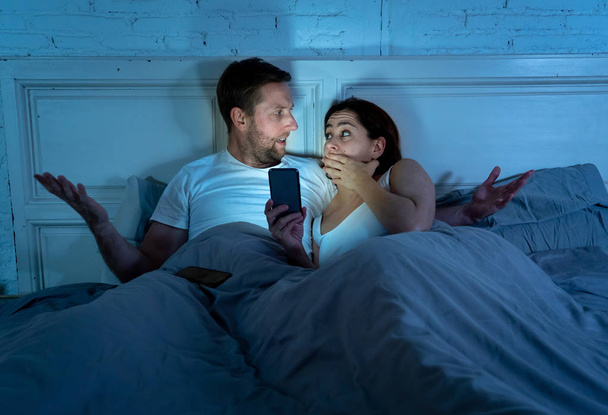 Angry man husband or boyfriend feeling jealous and betrayed by addicted to mobile phone wife girlfriend chatting online on phone to somebody in relationships problem and internet addiction concept. - Φωτογραφία, εικόνα