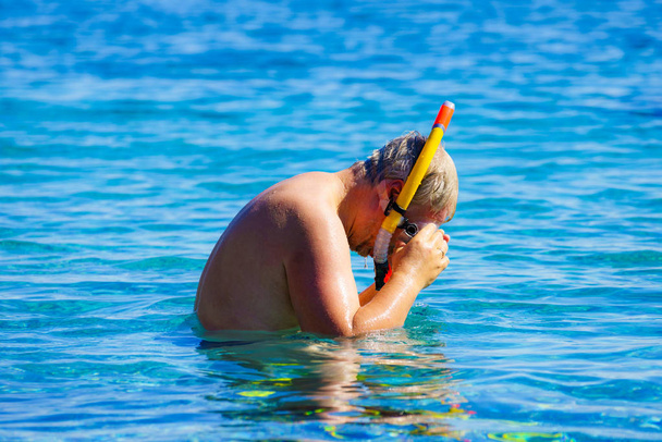 Hombre con tubo de snorkel en el mar
 - Foto, imagen