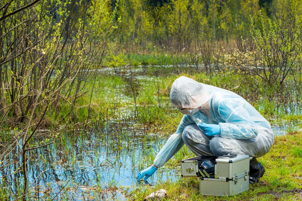 Эколог берет образец воды из лесного резервуара в
 - Фото, изображение
