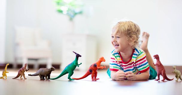 Kind spelen met speelgoed dinosaurussen. Kids speelgoed. - Foto, afbeelding