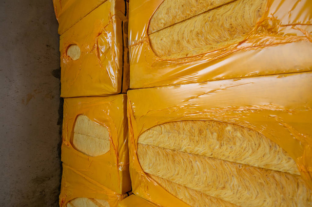 Stacks of packages with yellow thermal insulation, close up. Construction of new modern building - Photo, Image