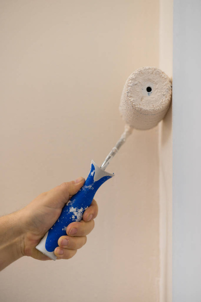 Person applying paint on wall - Φωτογραφία, εικόνα