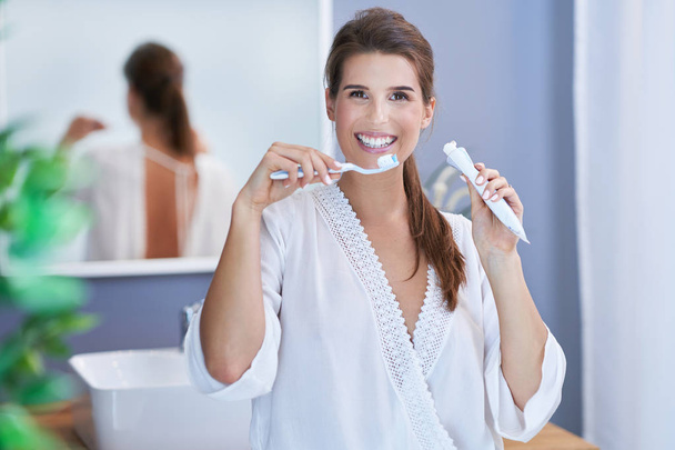Belle femme brune se brossant les dents dans la salle de bain
 - Photo, image