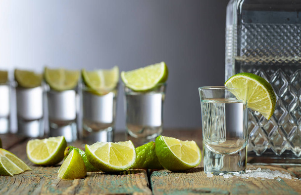 Tequila with  salt and lime on a old wooden background. - Photo, Image