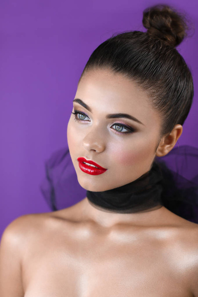 Brunette on a purple background with bright red lips - Foto, imagen
