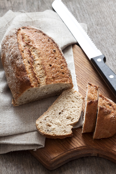 Pane integrale con fette su tavola di legno
 - Foto, immagini