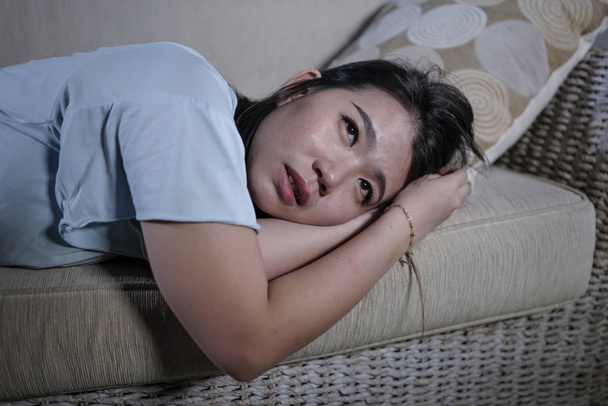 young sad and depressed Asian Japanese woman crying desperate sitting at home sofa couch suffering depression problem and anxiety crisis burst into tears - Foto, imagen
