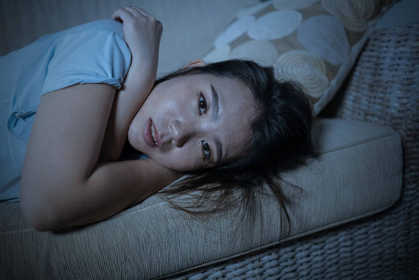 young desperate sad and depressed Asian Chinese woman sitting at home sofa couch suffering depression problem and anxiety crisis feeling lonely - Foto, immagini