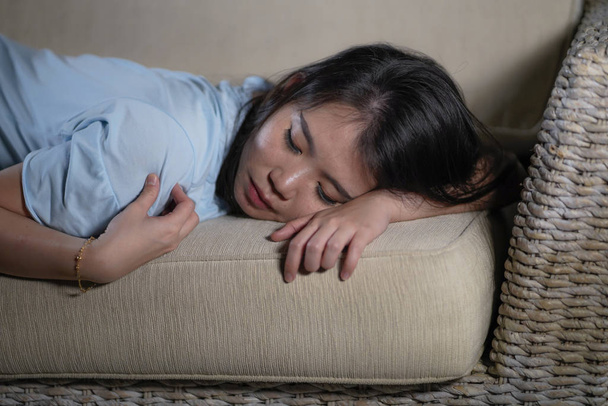 joven desesperado triste y deprimido asiático japonés mujer acostado en casa sofá sofá sufrimiento depresión problema y ansiedad crisis sentirse solo
 - Foto, imagen