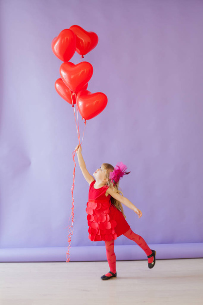 gyönyörű lány ül piros szív léggömbök - Fotó, kép