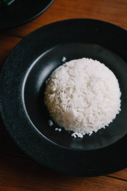 Ρύζι ατμού σε μαύρο πιάτο, minimal style - Φωτογραφία, εικόνα