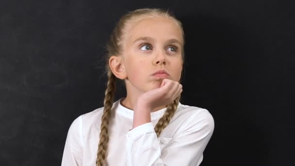 Thoughtful little schoolgirl shrugging shoulders, having no idea, bad pupil - Πλάνα, βίντεο