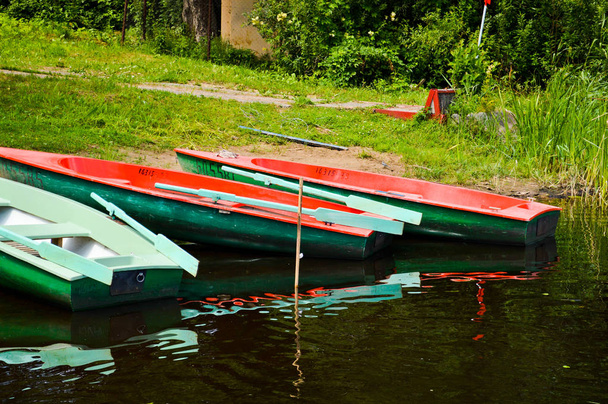 Piękne drewniane wielobarwne łodzie z wiosła na plaży na spacery wzdłuż rzeki, jezioro, morze, Ocean w parku przyrody na brzegu - Zdjęcie, obraz