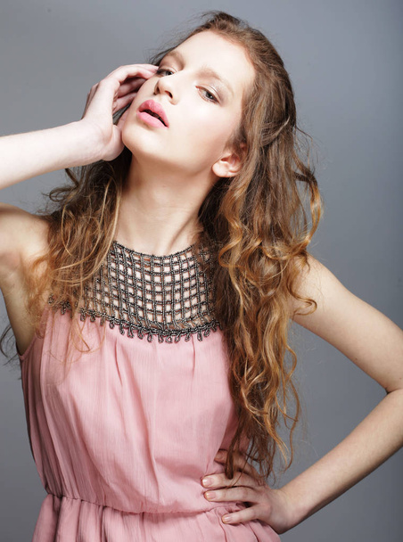 Fashion girl model posing on gray background in the studio. - Foto, Bild