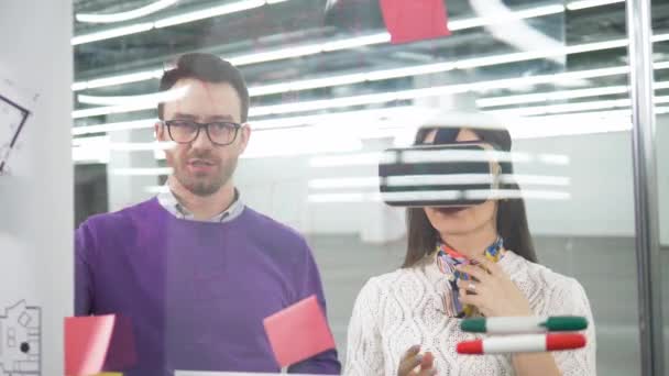 Female architect in VR-glasses and her male colleague are talking - 映像、動画