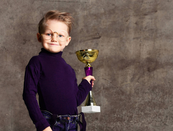Bambino festeggia il suo trofeo d'oro
 - Foto, immagini