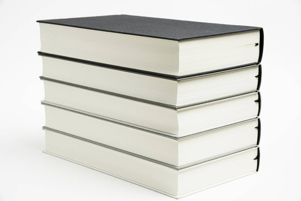 Un conjunto de libros atados de tela monocromática cuidadosamente apilados
 - Foto, imagen