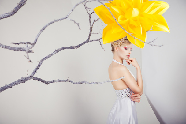 Blond woman in white dress with big yellow flower - Zdjęcie, obraz