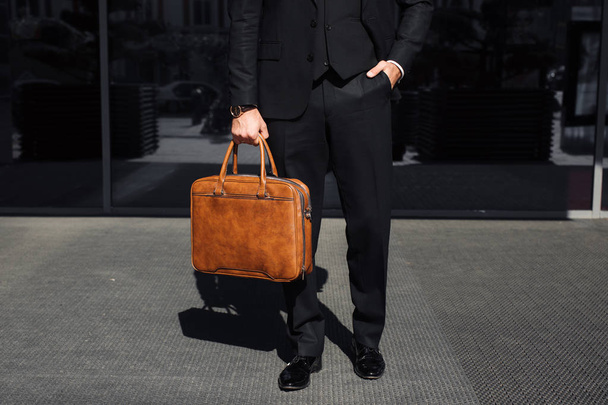 бизнесмен с сумкой рядом с офисом разговаривает по телефону
 - Фото, изображение