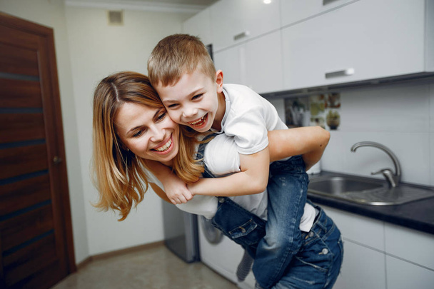 Cute mother with little son in a room - Фото, изображение