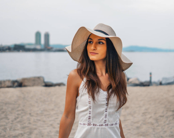 Pretty woman wearing white dress and pamela hat standing - Zdjęcie, obraz