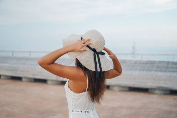 Beyaz elbise ve pamela şapka ayakta giyen güzel kadın - Fotoğraf, Görsel