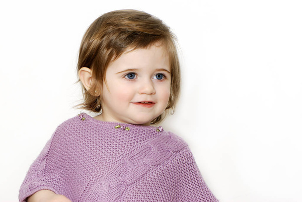 Portrait of little girl in purple woolen coat on white background  - Foto, afbeelding