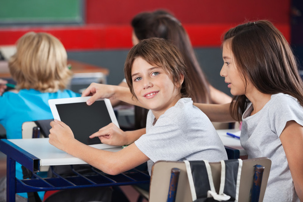 Niño con chica usando tableta digital en el escritorio
 - Foto, imagen