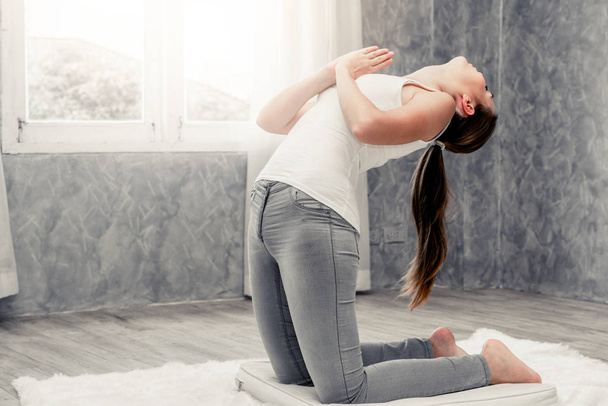 Young woman yoga on carpet at home living room.  - Foto, Bild