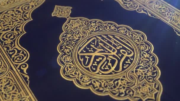 Голубая обложка Корана, украшенная золотом, с бликом объектива, неглубокая глубина резкости крупным планом, медленный наклон вниз CGI выстрел
. - Кадры, видео