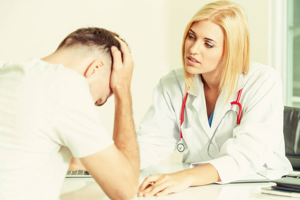 Woman Doctor and Male Patient in Hospital Office - Photo, Image