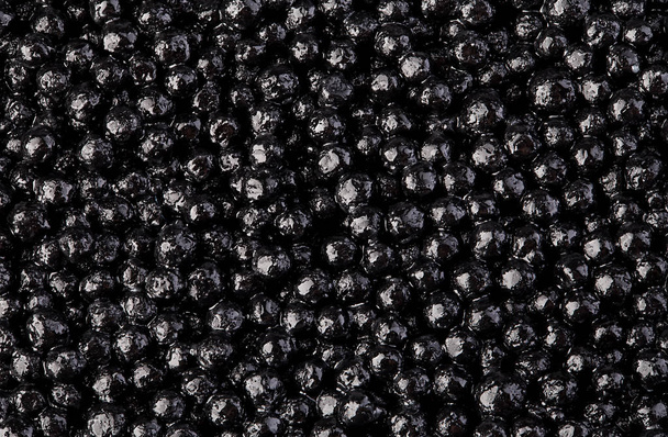 Zwarte steur kaviaar close-up als achtergrond. - Foto, afbeelding