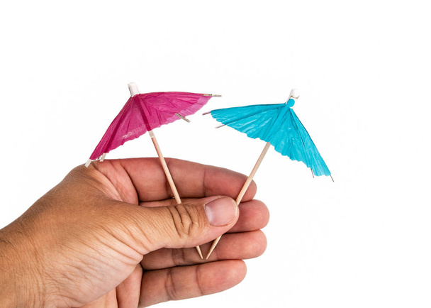 Держа коктейльный зонтик в руке
 - Фото, изображение