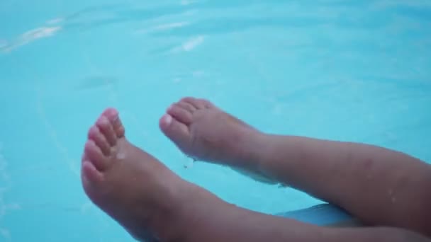 View on little girl legs playing in the water pool in summer day. - Imágenes, Vídeo
